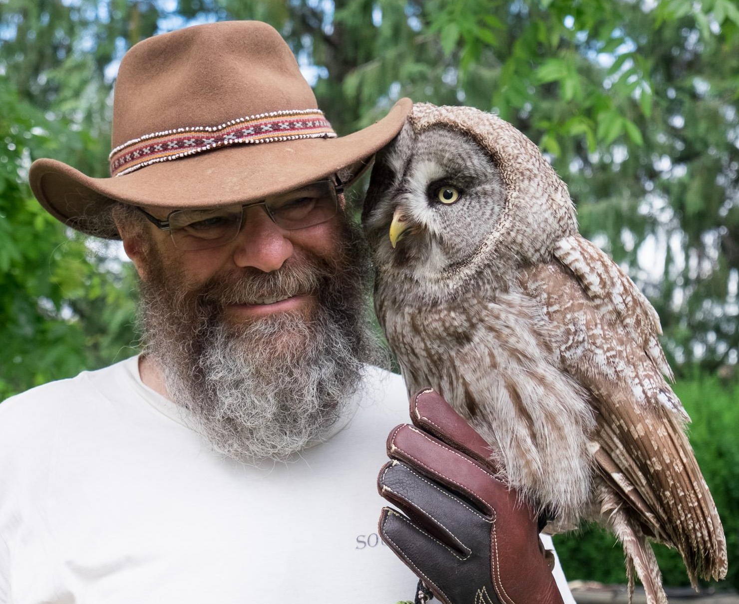Richard Grossman standing beside an owl